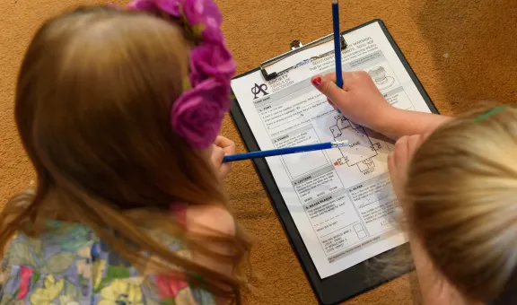 Two children filling out a Trails of Discovery form