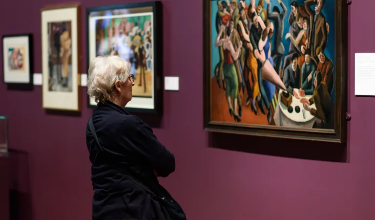 An Arts Society Member is looking at a painting in a gallery