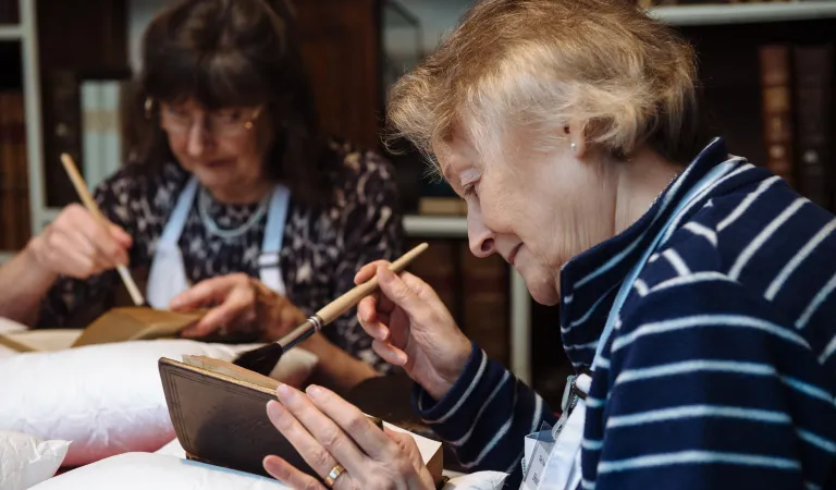 Photograph of Arts Society volunteers undertaking book conservation and preservation