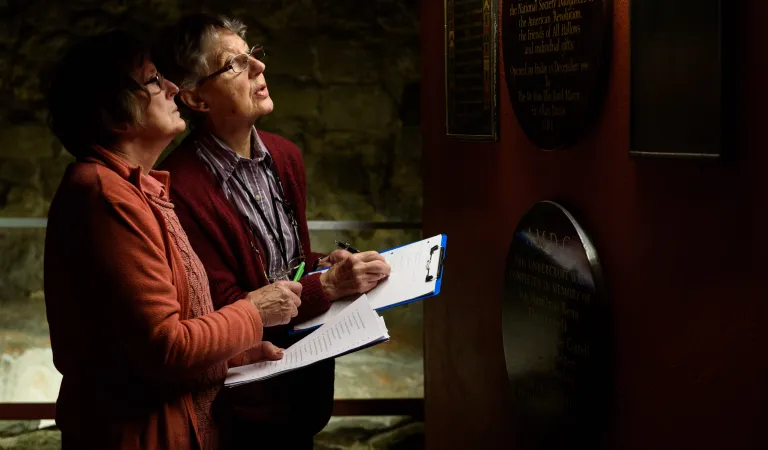 Two Arts Society Church Recorders look at items within a place of worship worship 
