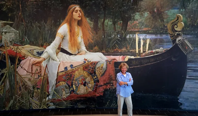 Photograph of Arts Society President Hilary Kay in front of a painting in Canberra