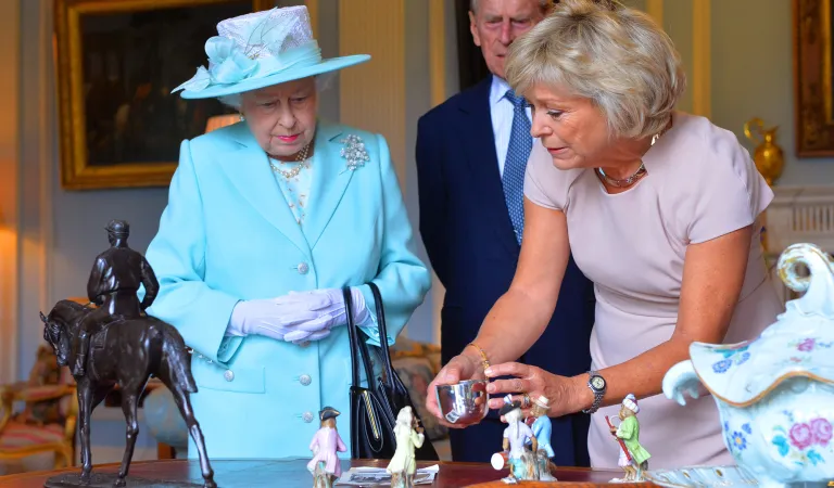 HM Queen Elizabeth II and The Duke of Edinburgh discussing an antique with Arts Society President Hilary Kay